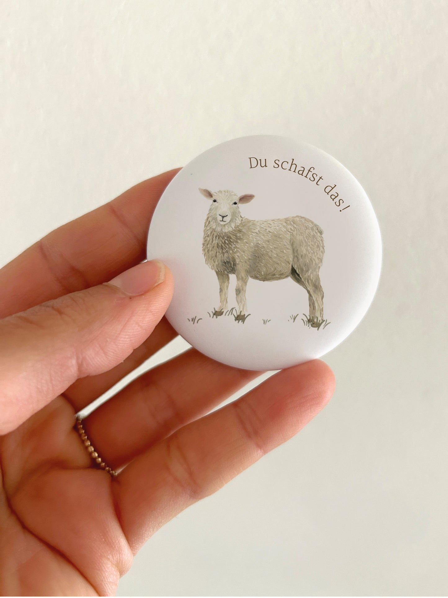Großer Motivations-Magnet Du schafst das mit 55mm Durchmesser als liebevolle Deko für die Magnetwand in der Küche oder Schule. Ein runder, matter Schaf-Kühlschrankmagnet wird als Größenvergleich in einer Hand gehalten, um das spiegelungsfreie Schutzlaminat anschaulich zu präsentieren.