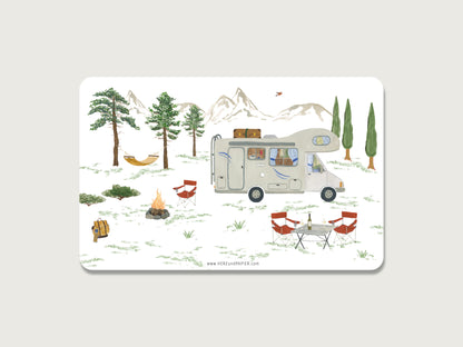 Frühstücksbrett mit handillustriertem Wohnmobil-Motiv. Der Camper steht inmitten der Natur vor einer Bergkulisse und einigen Bäumen. Es ist eine Hängematte gespannt, Camping-Stühle aufgebaut und ein Lagerfeuer zu sehen. 