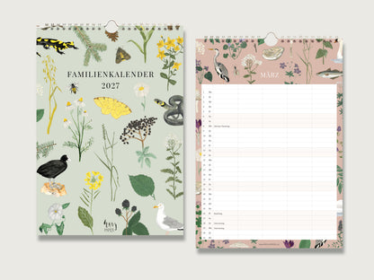 Familienkalender-Natur-1.jpg:Produktfoto zweier geöffneter Seiten eines Wandkalenders 2027 mit Spiralbindung auf hellem Hintergrund. Links das hellgrüne Deckblatt mit dem Titel "FAMILIENKALENDER 2027" in dunkler Schrift. Es ist dicht geschmückt mit botanischen und zoologischen Illustrationen wie einem Feuersalamander, einem Marienkäfer, Bienen, verschiedenen Blumen (Kamille, Rainfarn, Wiesenblumen), einem Schwalbenschwanz-Schmetterling, einer Ringelnatter, einer Brombeere und zwei Vögeln (Wasserhuhn, Möwe).