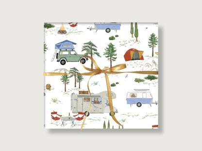 Geschenk mir bunt gewürfeltem Camping-Motiv. Auf dem Geschenkpapier sind Wohnwägen (Eriba), Jeep mit Dachzelt und Wohnmobile zu sehen. Um die Fahrzeuge sind Campingstühle, Lagerfeuer und Landschaft und Natur zu sehen. 