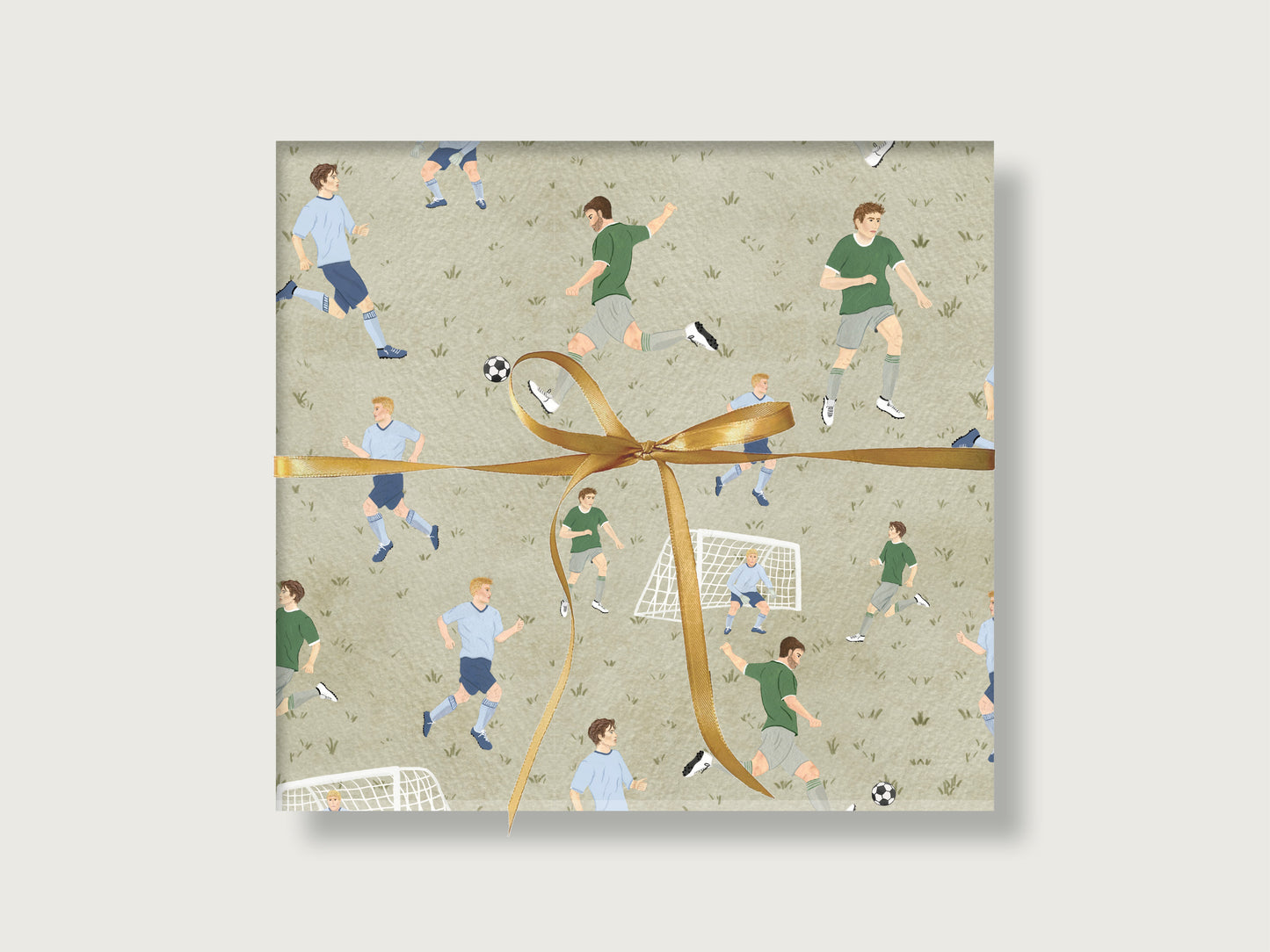 Geschenk mit Fußball-Geschenkpapier. Da sind auf grünem Hintegrund verschiedene Fußballer zweier Mannschaften und ein Tor. Es ist eine Fußballszene nachgestellt. 