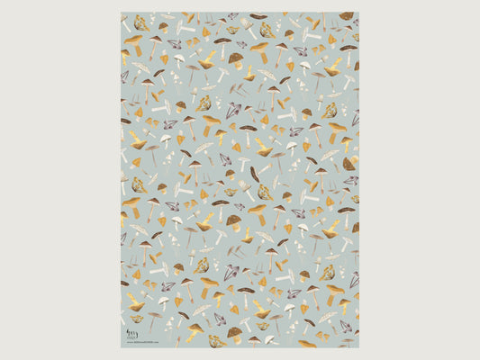 Das ausgebreitete Geschenkpapier mit herbstlichen Pilzillustrationen liegt glatt auf dem Tisch und zeigt das gleichmäßige Muster auf hellblauem Grund.