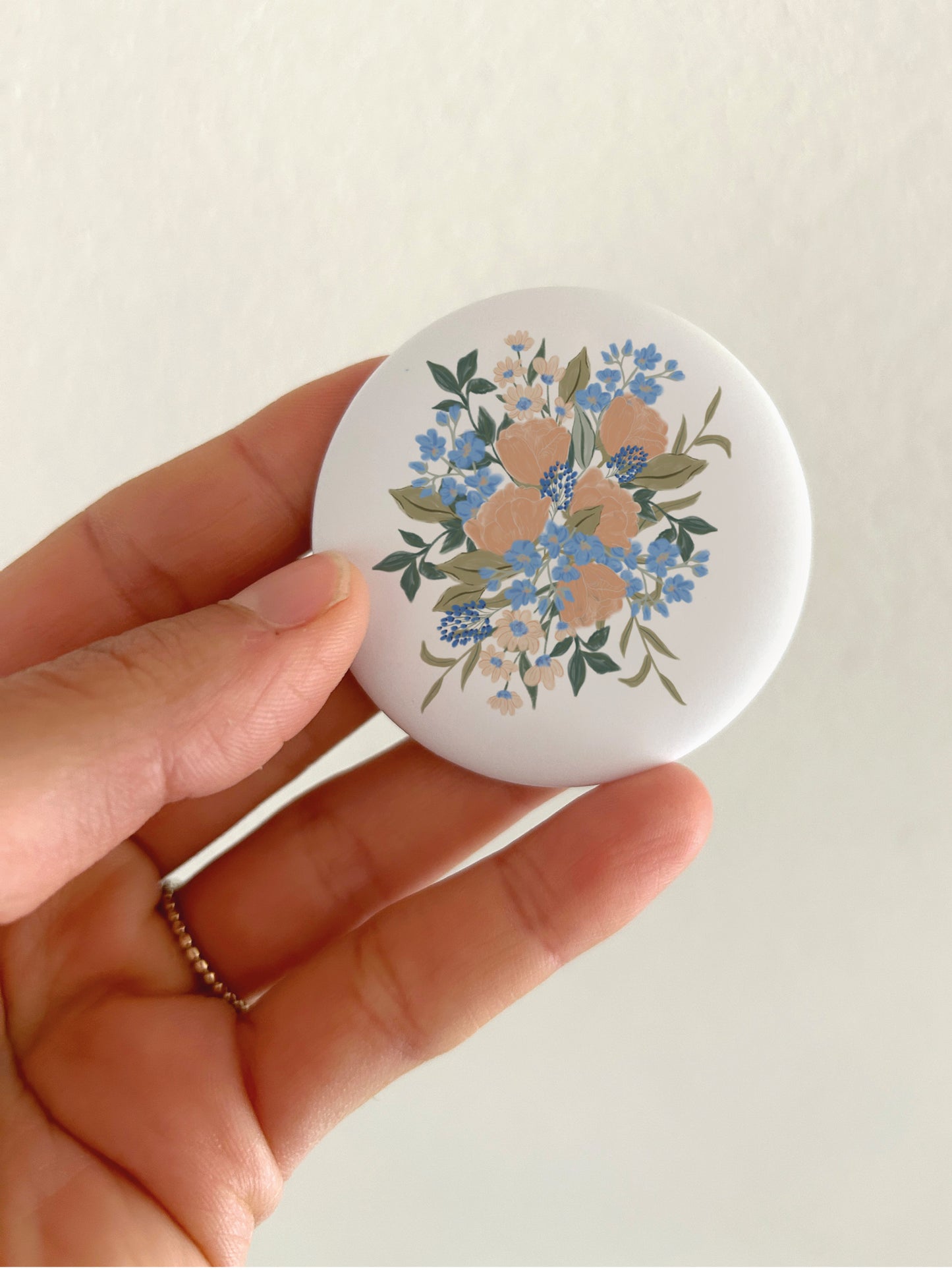 Botanischer Blumen-Kühlschrankmagnet mit 55mm Durchmesser als Deko für die Magnetwand in der Küche, Kühlschrank, zur Veranschaulichung der Größe in der Hand gehalten.