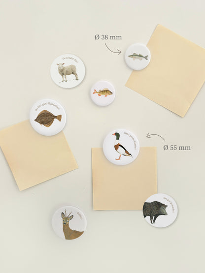 Magnetwand mit runden Magnetbuttons oder Kühlschrankmotiven mit Tier und dazu passendem Wortwitz. Die lustigen Magnete sind mit Tieren wie Flunder, Gans, Reh, Schaf und Wildschweinbedruckt. Die Illustration ist handgemalt 