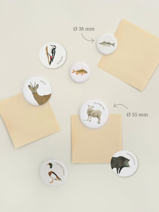Magnetwand mit runden Magnetbuttons oder Kühlschrankmotiven mit Tier und dazu passendem Wortwitz. Die lustigen Magnete sind mit Tieren wie Flunder, Gans, Reh, Schaf, Specht und Wildschweinbedruckt. Die Illustration ist handgemalt 