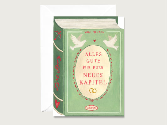 Illustrierte grüne Hochzeitskarte im Buch-Design mit weißen Tauben, Eheringen und dem Spruch „Alles Gute für euer neues Kapitel“, dahinter ein weißer Umschlag.
Die Motiv der Karte ist handgemalt. 