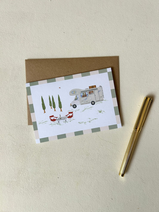 Liebevoll gestaltete Klappkarte zum Thema Camping und Vanlife mit Aquarell-Wohnmobil, Campingtisch und Zypressen, platziert auf einem Umschlag aus Kraftpapier.