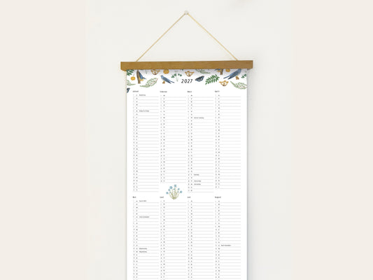 Langformatiger Wandplaner 2027 mit handillustrierten Vögeln, Schmetterlingen und botanischen Aquarell-Motiven, aufgehängt an einer Holzleiste vor einer weißen Wand.